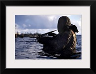 A Navy SEAL emerges from underwater during a training exercise