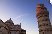 Sunlight on the top of the Leaning tower of Pisa at dusk, with the Duomo