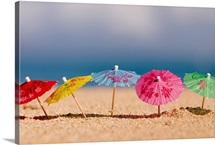 Close-Up Of Cocktail Umbrellas In The Sand