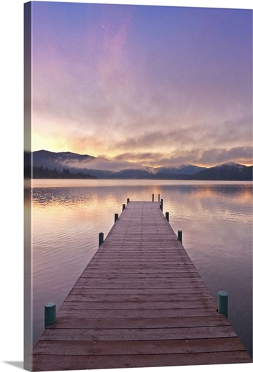 Footprints leading down a frost covered dock at sunrise on Lake Whatcom during Winter