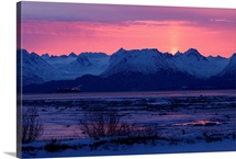 Sun sets over rugged mountain landscape