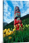 Totem pole with tulips Juneau Southeast Alaska mountains coast summer tourist
