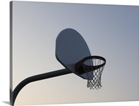 A basketball backboard hoop and net. Clear blue sky