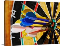 Dartboard with darts in bulls eye.