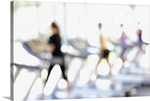 Defocused view of people on treadmills in health club
