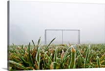 Frost and fog and football goal on soccer field.