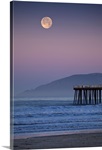 Full moon sets over  Pismo Beach at sunrise on winter morning.