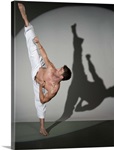 Male martial artist performing kick, studio shot