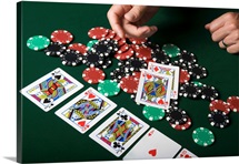 Man throwing playing cards onto pile of poker chips