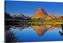 Painted Teepee mountain, Mt. Sinopah and Lone Walker mountain reflected in Pray Lake.