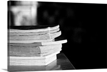 Pile of paperback books on desk in school library.