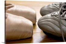 still life of ballet shoes and football boots