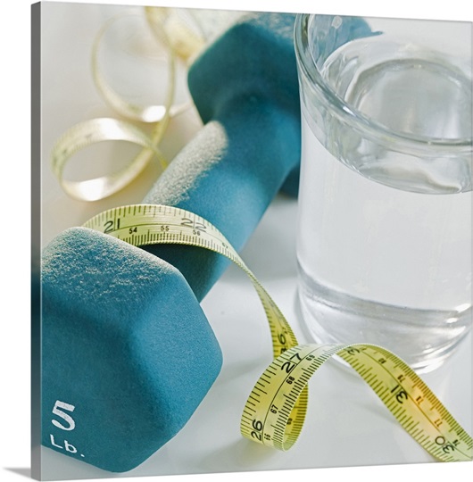 Tape measure, exercise weights and glass of water, studio shot