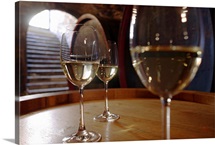 Wite wine in glasses on wine cask