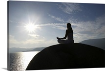Woman meditating on rock