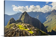 Sun shining through the Andes mountains onto Machu Picchu at sunset