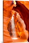 Sunlight streams through cracks in a slot canyon