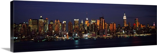 Skyscrapers lit up at night in a city, Manhattan, New York City, New York State