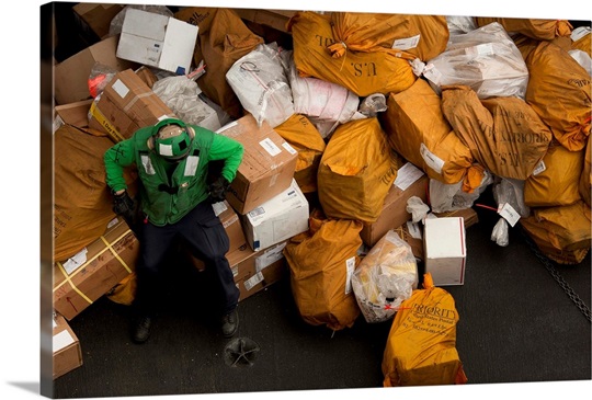 A Sailor waits to move mail below decks