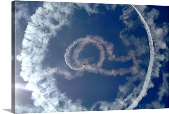 A stunt plane flies around a parachutist
