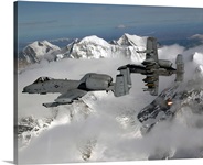 A10 Thunderbolt IIs fly over mountainous landscape