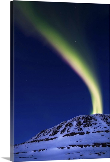 An aurora borealis shooting up from Toviktinden Mountain, Norway