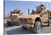 An M ATV Mine Resistant Ambush Protected vehicle parked next to a MaxxPro MRAP