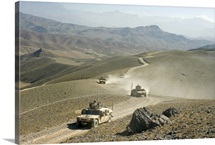 Humvees traverse rugged mountain roads
