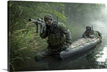 Navy SEALs navigate the waters in a folding kayak during jungle warfare operations