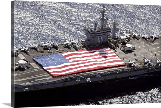 Personnel participate in a flag unfurling rehearsal on the flight deck aboard USS Nimitz