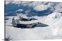 Two F-15 Eagles fly past snow-capped peaks in Central Oregon