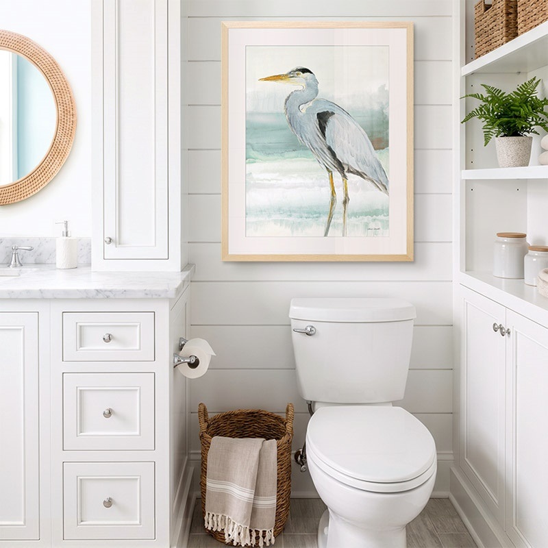 framed print of a painting of a heron in a coastal bathroom