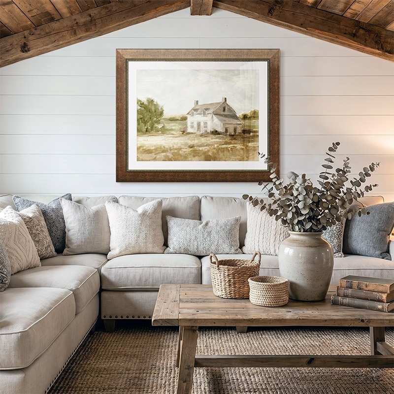 framed print of a painting of a barn hanging in a farmhouse living room