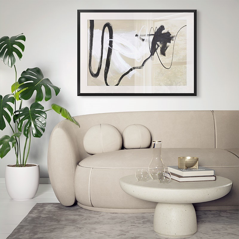 Framed print of minimalist abstract art hanging over a couch in a neutral living room