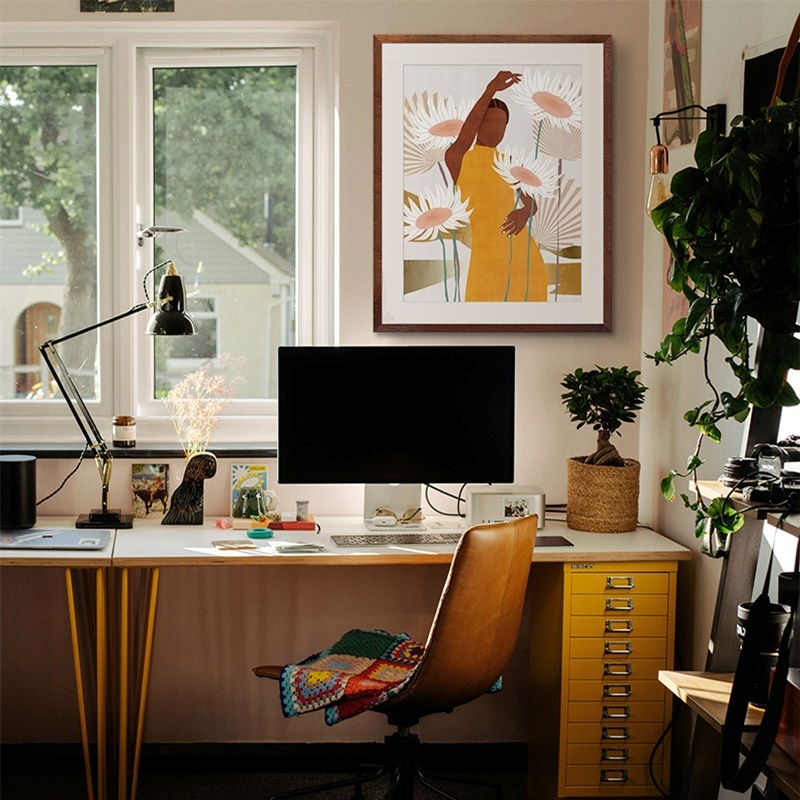 Framed print of the silhouette of a woman and flowers in a boho office