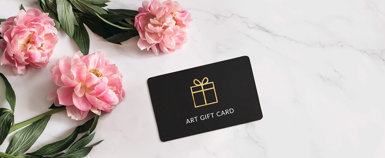 a giftcard on a table next to pink flowers