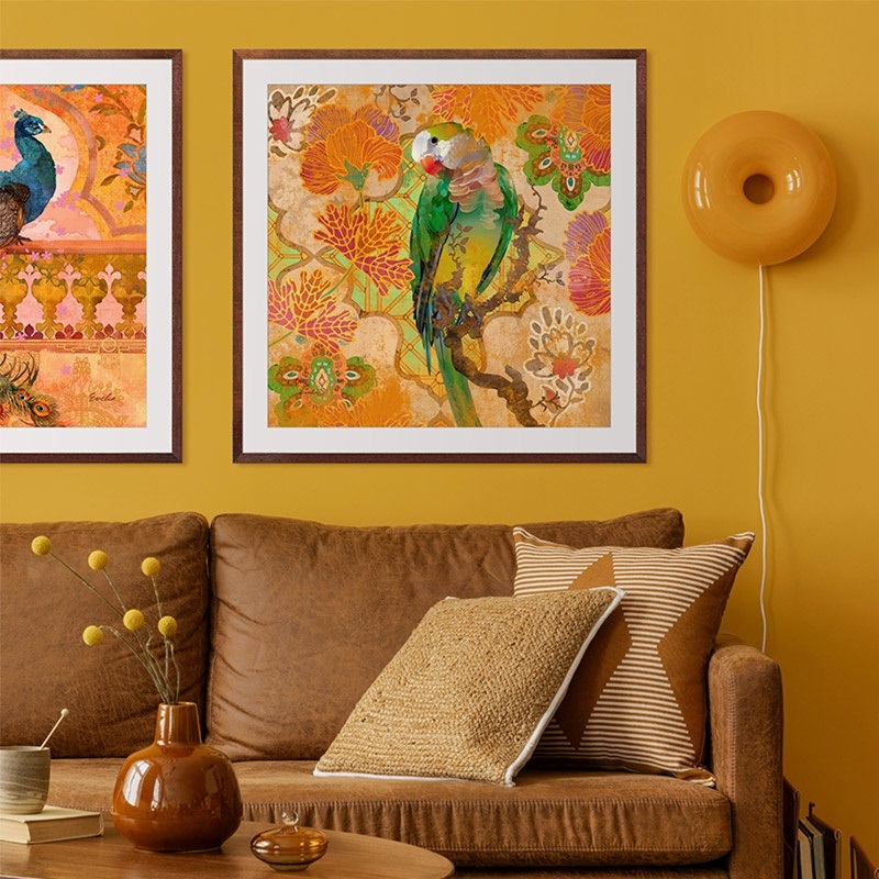 a framed art piece of a bird hanging above a couch