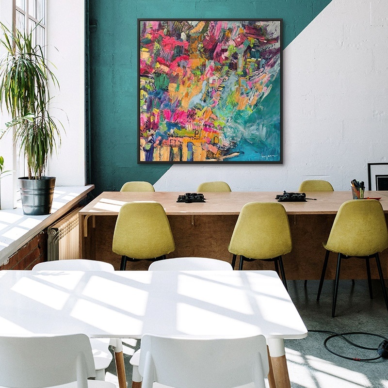 Two canvas prints of green abstract paintings in a hotel lobby