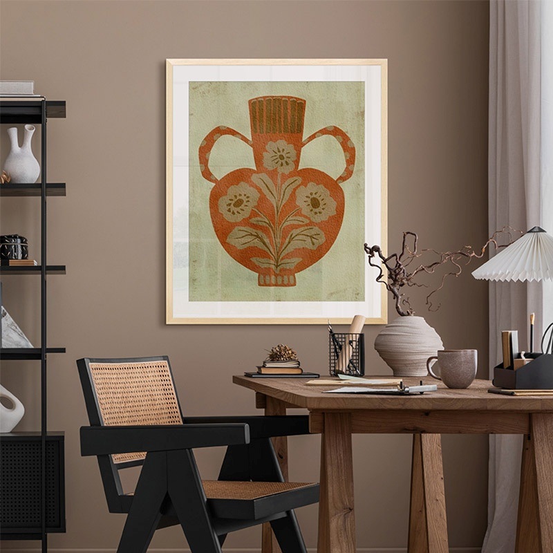 a framed print of a ceramic vase in a boho office