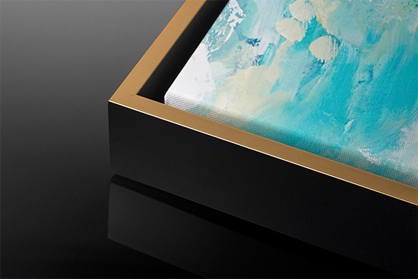 a close up of the front corner of a canvas with a gold floating frame