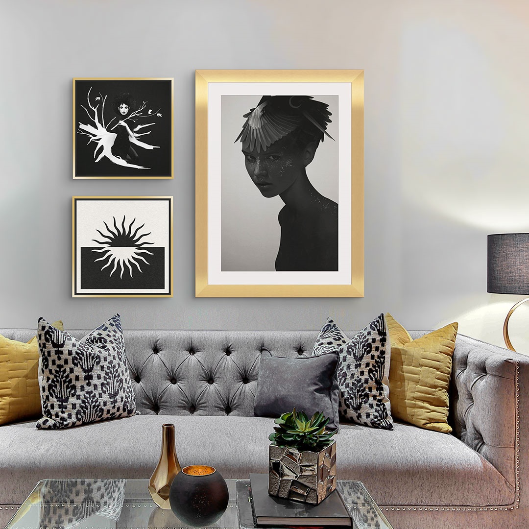 two canvas prints and one framed print of two women and a sun in black and white above a couch