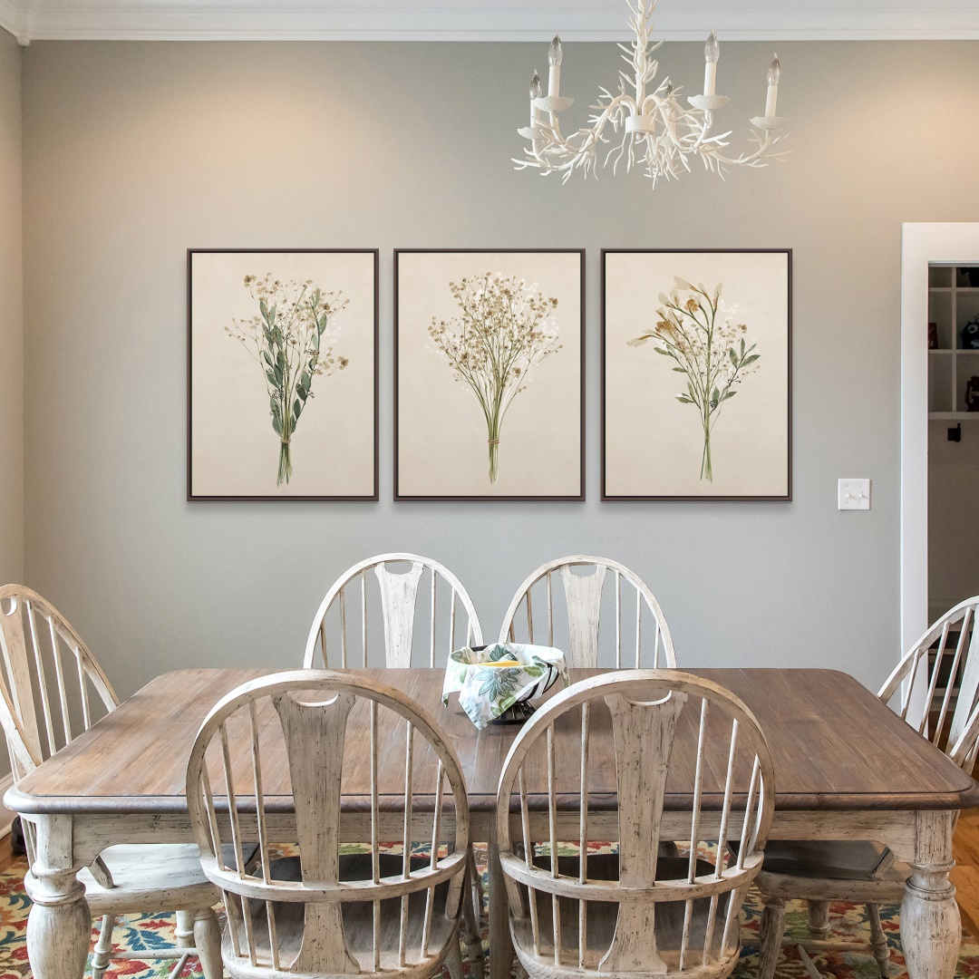 three framed canvas prints depicting dried flowers hung in a farmhouse styled dining room