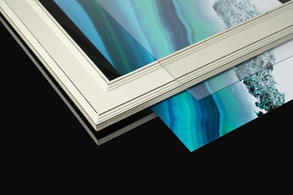 a deconstructed framed print set, with the art print, frame, and glass covering stacked on top of ea