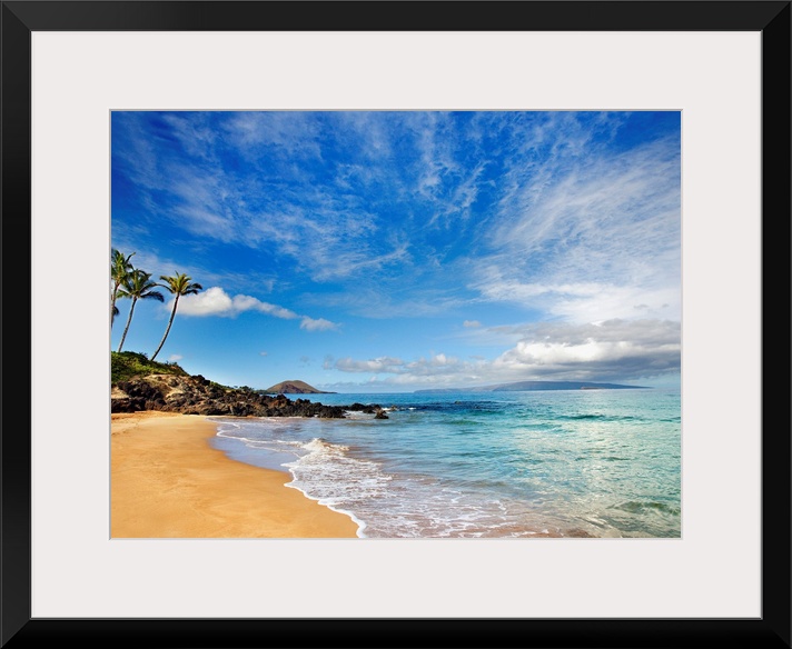 Tropical beach with small, calm waves under a partly cloudy sky, with a few palm trees in the distance.