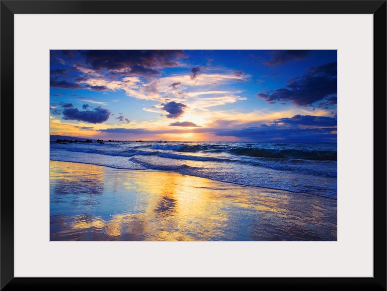 Horizontal photograph on a large wall hanging of a vivid sunset glowing through clouds, over the shore of Mokapu Beach in ...