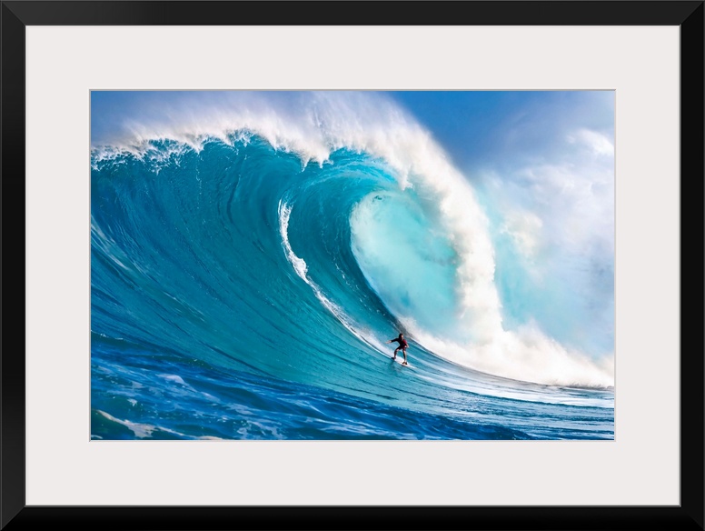 A tow-in surfer drops down the face of Hawaii's big surf at Peahi (Jaws) off North shore Maui; Maui, Hawaii, United States...