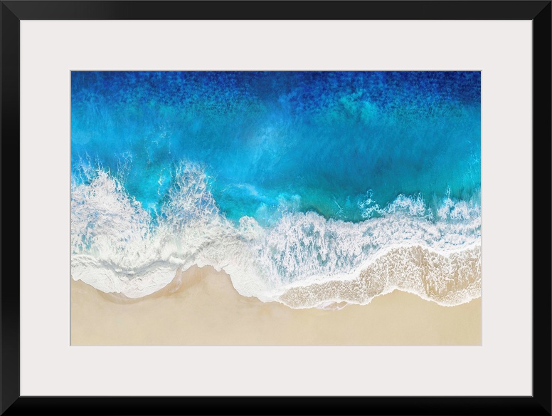 One artwork in a series of aerial shots of a beach as blue waves break upon the shore.