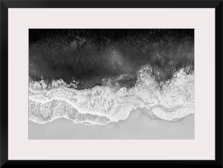 One artwork in a series of aerial shots of a beach as dark gray waves break upon the shore.