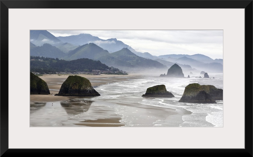USA, Oregon, Cannon Beach. Fog rises over coastline at low tide.