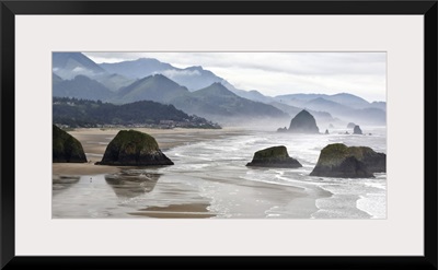 Oregon, Cannon Beach. Fog rises over coastline at low tide